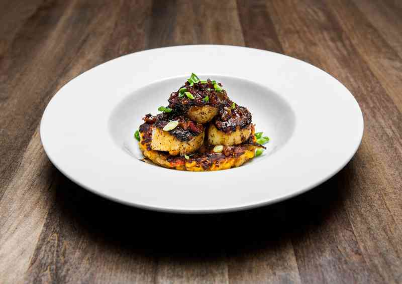 Traditions on the Lake's blackened scallops are served on a Cajun corn fritter and topped with a sweet bacon-pepper jam.